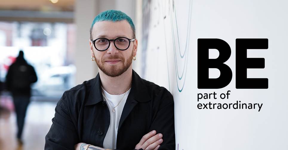 A person with blue hair and glassesDescription automatically generated