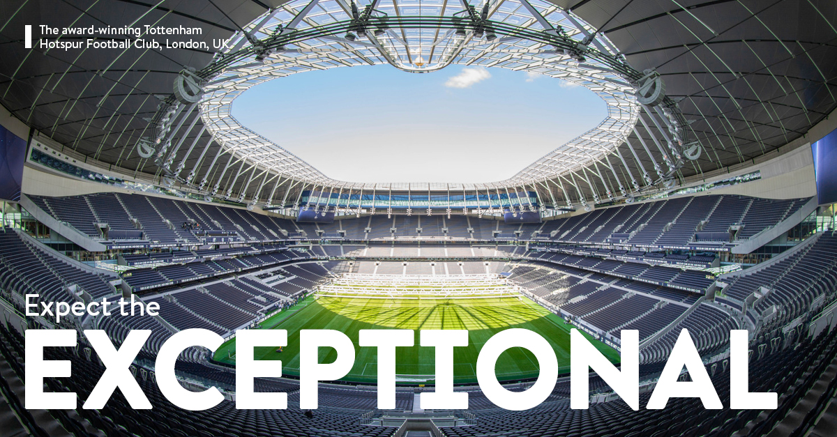 A stadium with a green field and a skylightDescription automatically generated