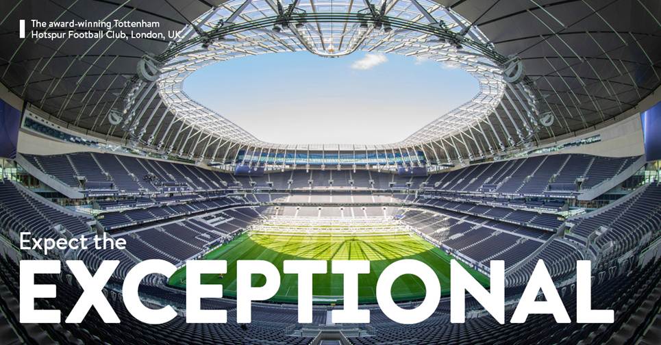 A stadium with a green field and a skylightDescription automatically generated